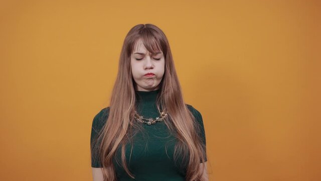 Upset offended looking big eyes, blowing cheeks being annoyed after quarrel with her husband, inflating not wanting to do something, bad mood, fascinating, cut, pouted. Young attractive woman, green