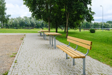 equipped recreation area in the city park with wooden benches and tables