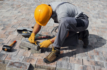Male worker in yellow colored uniform have job with pavement