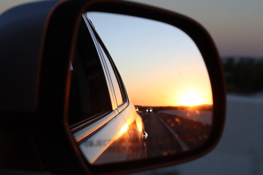 rear view photo of the car, where you can see the sunset on a highway