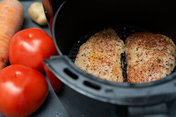 Cooking skinless chicken breast with spices in an air fryer