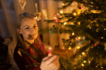 Woman Decorates Christmas Tree for Winter Xmas Holidays. Xmas Background.