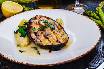 Grilled salmon steak with potato and spinach on white plate