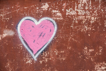 Pink heart on the grunge wall background