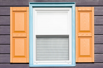 Colorful, modern colors on a window with shutters.