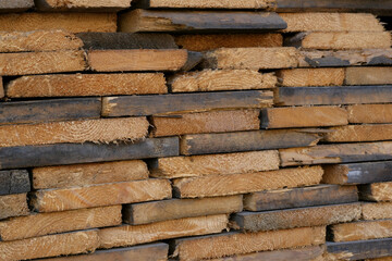 The wood from the old boards. Woodpile made of boards.
