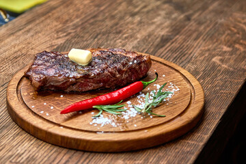 Master chef cooking barbecue Beef Grilled steak meat with fire flames on wooden table