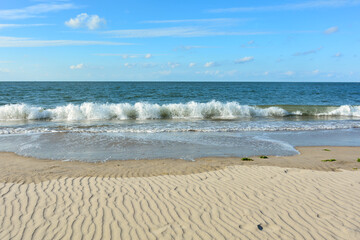 Sea with wave  on sand beach with blue sky