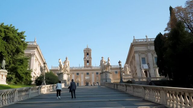 Ascending the Cordonata Stairs that lead to Piazza del Campidoglio with the view of marble statues at the top