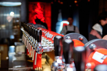 Bartender pouring beer standing at the bar counter. Pouring a large lager beer in tap for client.