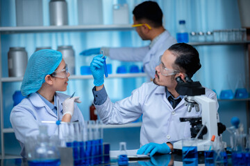 Fototapeta premium group of laboratory assistants checking blood, using microscope and doing test for bacteria