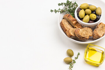 Olives and slices of bread in ceramic bowl