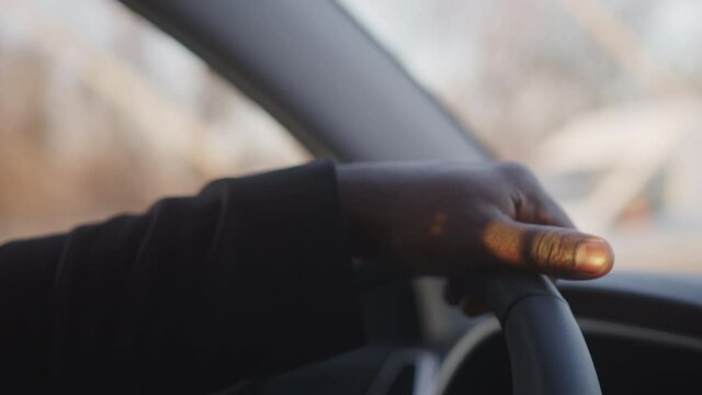Close up of hand on the steering wheel. African american black man driving a car. High quality 4k footage