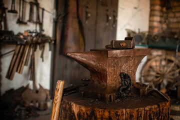 Blacksmiths tools, hammer and anvil in old Blacksmiths workshop, an ancient craft, old forge with a burned oud furnace with lots blacksmith's equipment