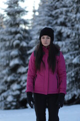 Girl on winter snowy fir tree background on ski resort