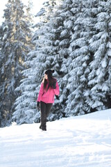 Fototapeta na wymiar Girl on winter snowy fir tree background on ski resort