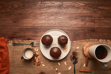 chocolate cupcakes with coffee and almond milk on a wooden table