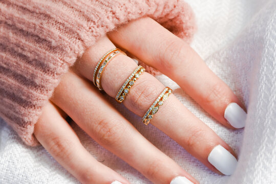 Hand with stackable rings and sweater