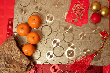 Chinese new year arrangement with table and red background with red and silver decorations, tablecloths and tangerines