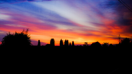 Sylwetki w mieście o zachodzie słońca na tle nieba