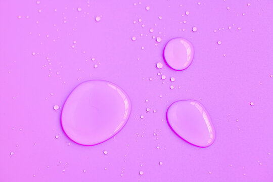Full frame of the textures formed by the bubbles and drops of water. Drops of water spilled on a light pink surface