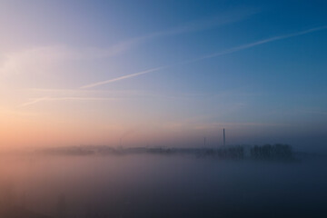 Fototapeta na wymiar Wschód słońca we mgle nad wodą