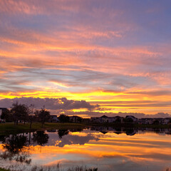 Fototapeta premium Beautiful pink, orange and blue sunset reflecting on a lake.