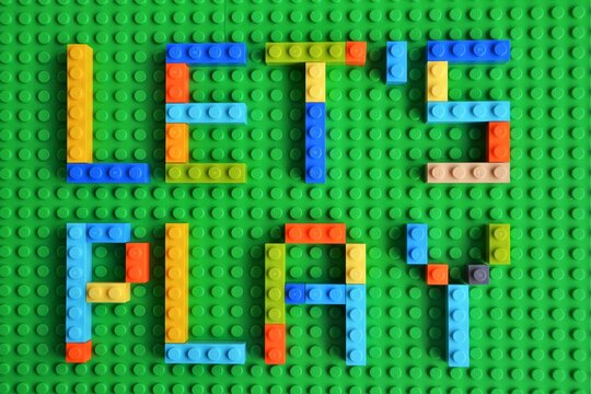 LET'S PLAY colorful inscription on the green base/plate/board. Letters made of Lego bricks. Warsaw, Poland - September 6 2018