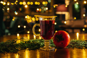 Mulled wine with persimmon and mango on the table in restaurant. Winter and autumn hot alcoholic...