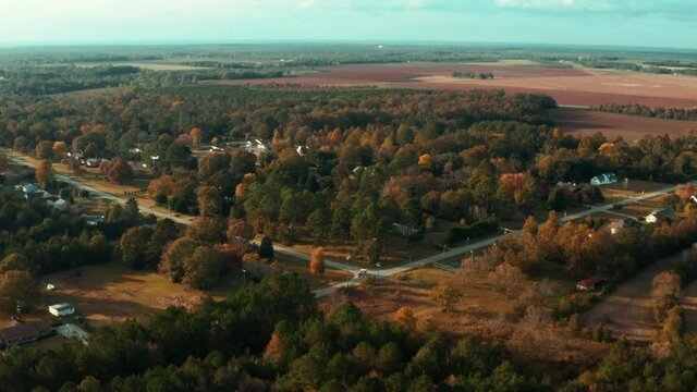 Aerial Shot Of A Rural Roadway Beside A Subdivision With A Fire Truck Turning The Corner