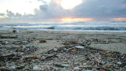 Micro plastics particles pollution on dirty sea coast,sunset time,environmental waste report