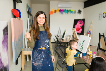 Portrait of a pretty teacher in a art classrom for children