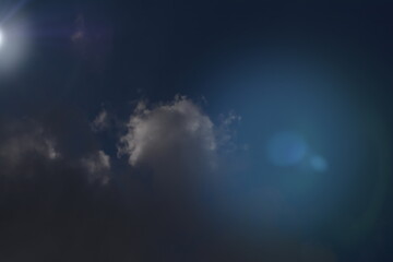 Light in the Dark and Dramatic Storm Clouds with lens Flare. 