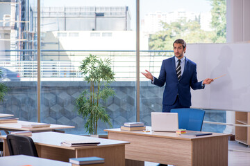 Young male teacher in suit in the classroom