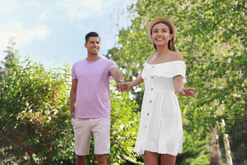 Lovely couple walking together in park on sunny day