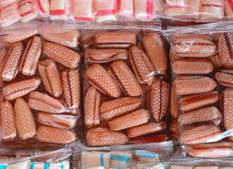 Multicolored candies in an transparent plastic wrap as a background.