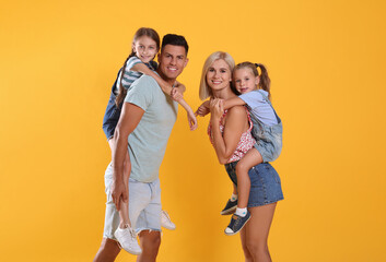 Fototapeta premium Portrait of happy family on yellow background