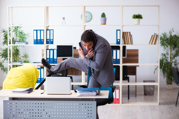 Young male employee looking after newborn at workplace