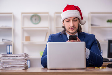 Young male employee working in the office at Christmas Eve