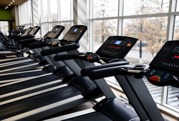 Treadmills in modern gym and fitness center with equipment and exercise machines