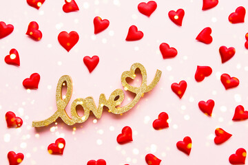 Valentines Day concept. Red hearts and word LOVE on pink background.