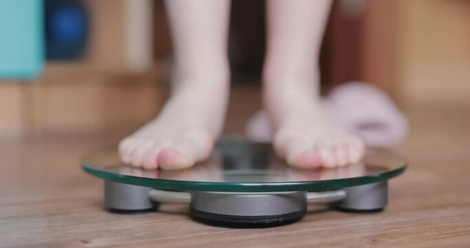 Woman is weighed on the scales close up