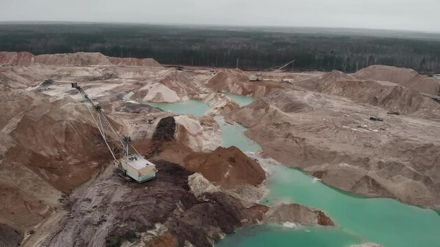 Top view of big excavator works at sand quarry, loads and transporting sand from lake. Industrial mining quarry. Quarrying extractive industry. Sand quarry, sand extraction for construction industry
