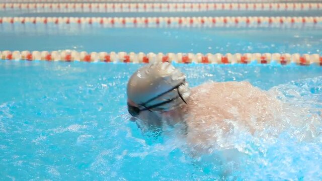 Male swimmer doing butterfly stroke during training in swimming pool, Slow motion. High quality FullHD footage
