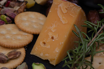 Aged Cheddar cheese closeup on slate board