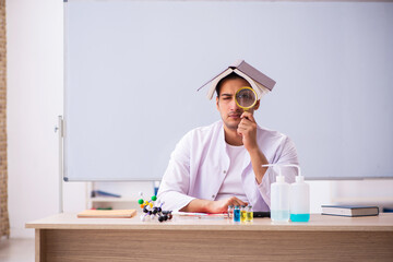 Young male chemistry teacher in the classroom