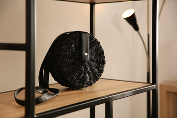 Elegant black bag on shelf in luxury boutique