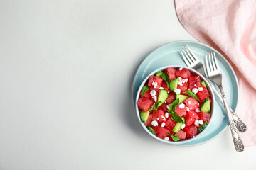 Delicious salad with watermelon, cucumber and cheese on white table, flat lay. Space for text