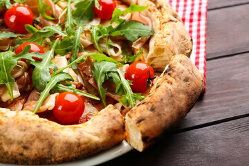 Tasty pizza with meat and arugula on wooden table, closeup