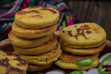 Traditional Mexican gorditas or arepas stacked on clay plate